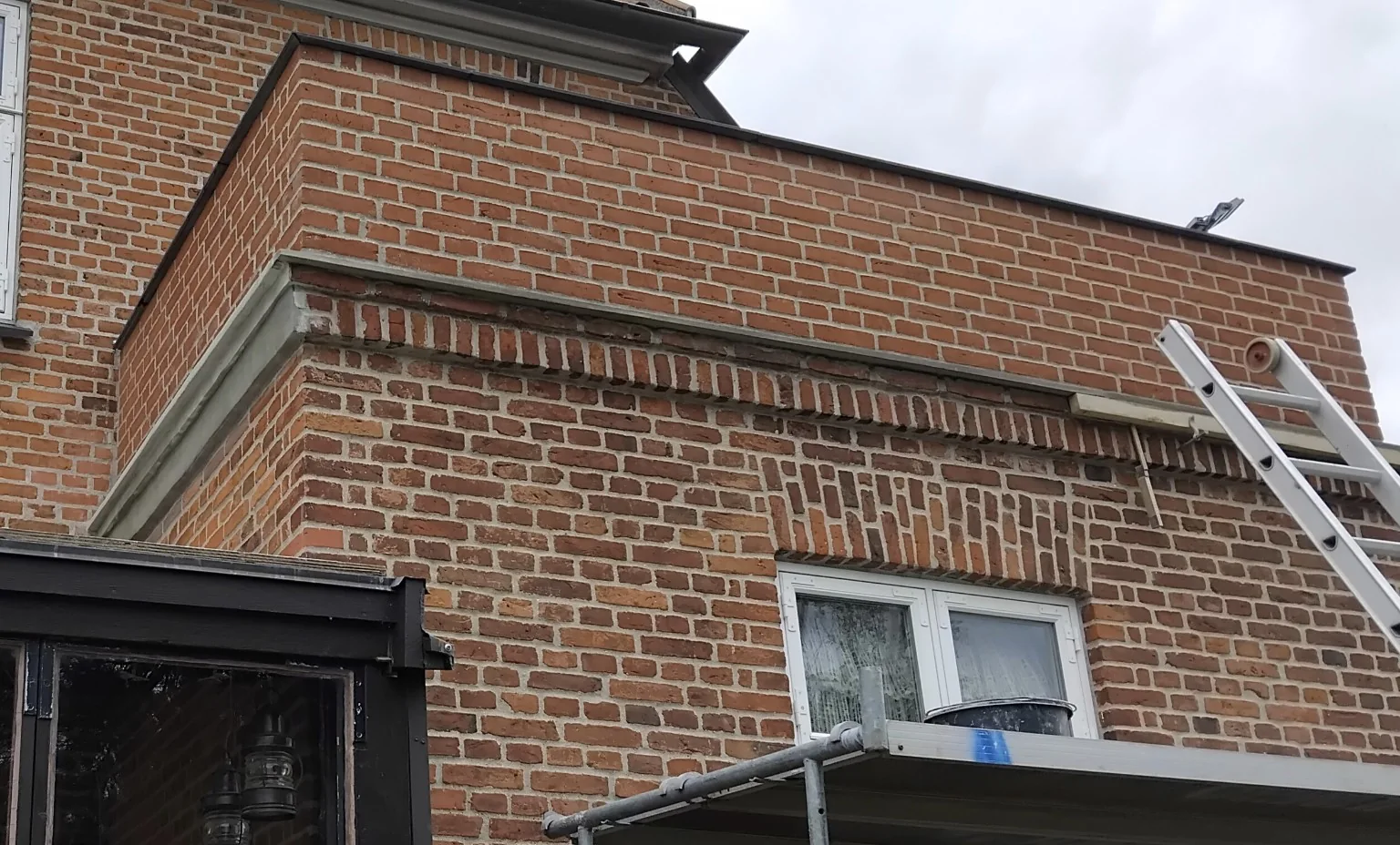 Gesims under renovering med synlige reparationer og stillads